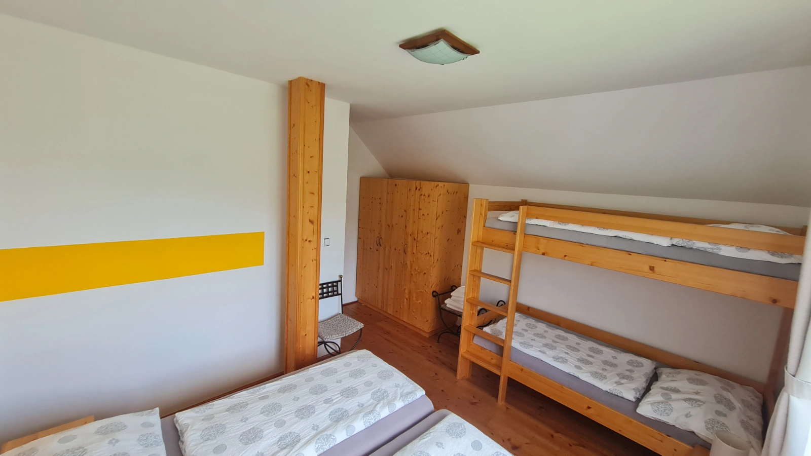 Pokoj s postelemi a křeslem